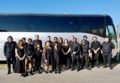 Performers posing in front a bus.