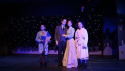 Theatre production still shot of two adults and two children with a starry background.