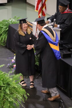 Female graduate receives diploma from Interim President Phillips