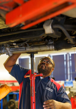Wallace automotive student examining car in school shop